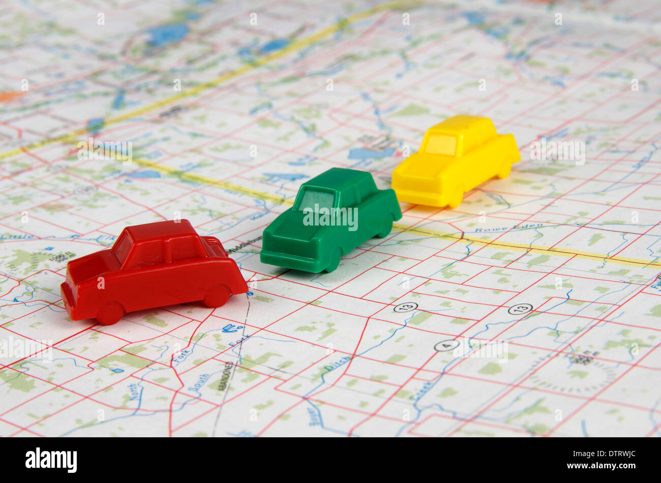 Miniatur-Autos von rot, grün und gelb, die Reisen über eine Karte in einer Fahrgemeinschaft Mode. Stockfoto