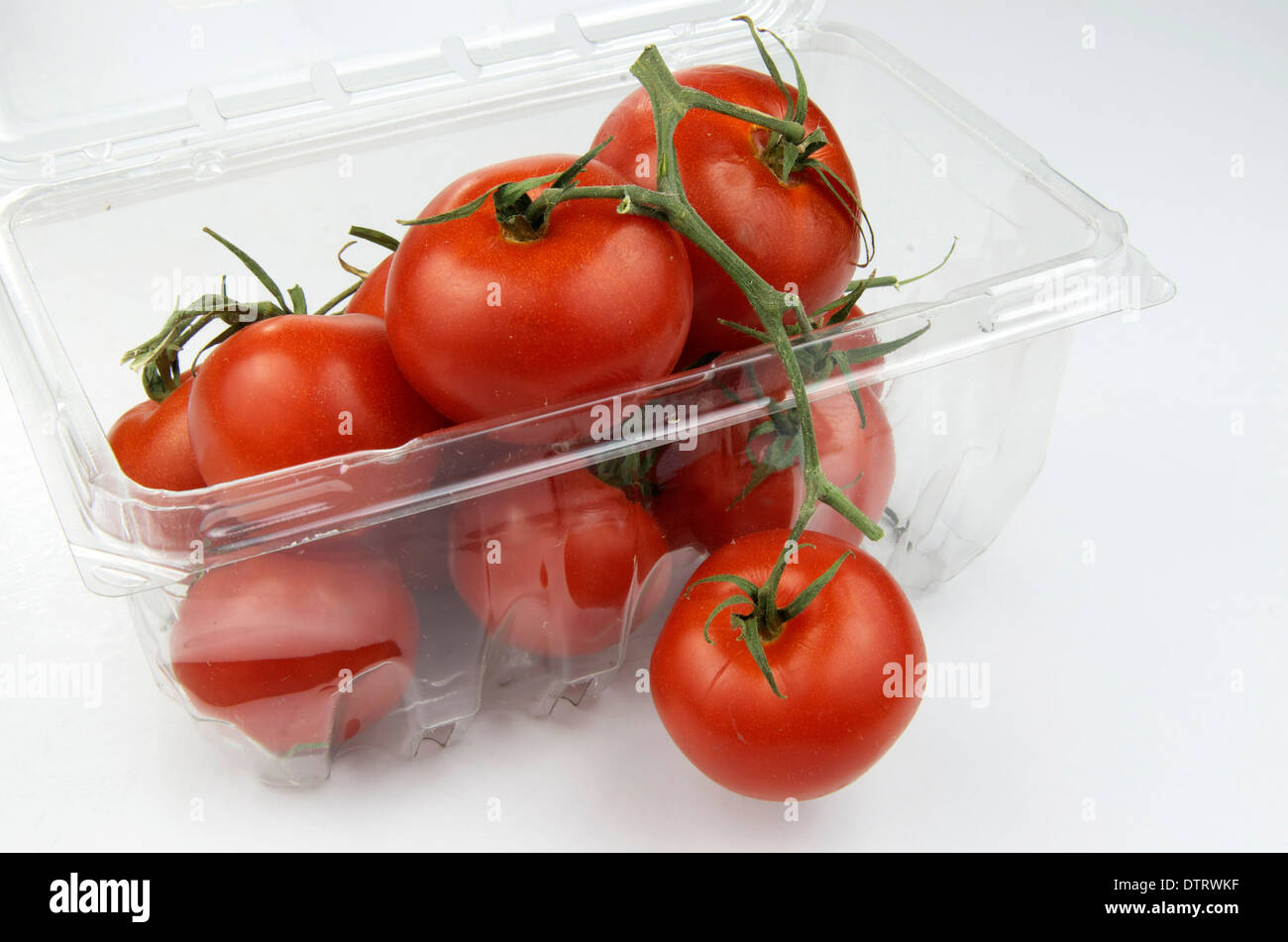 Rebe reife Tomaten in einem Plastikbehälter aus dem Lebensmittelgeschäft. Stockfoto