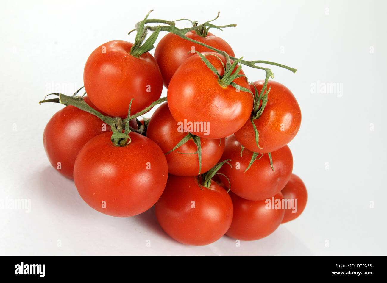 Stapel der Rebe reife Tomaten auf weiß. Stockfoto