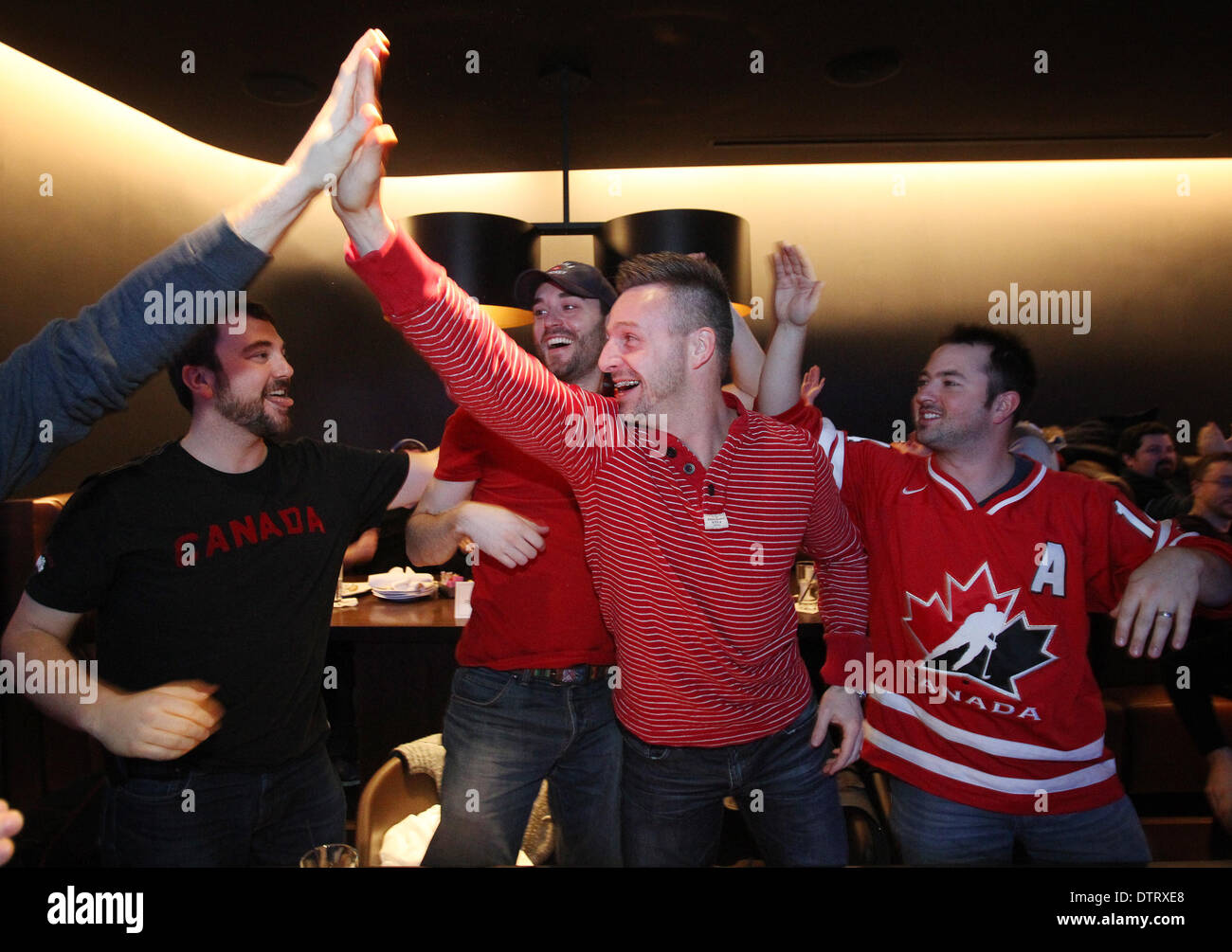 In Ottawa. 23. Februar 2014. Kanadier feiern, wie sie die olympische Goldmedaille Eishockey-Spiel zwischen Kanada und Schweden im Real Sports Bar & Grill in Ottawa, Kanada am 23. Februar 2014 zu sehen. Kanadier jubelten aus Bars, Gemeindezentren, als die kanadische Männer Eishockey-Team die Goldmedaille mit einem 3: 0-Sieg nahm. © Cole Burston/Xinhua/Alamy Live-Nachrichten Stockfoto