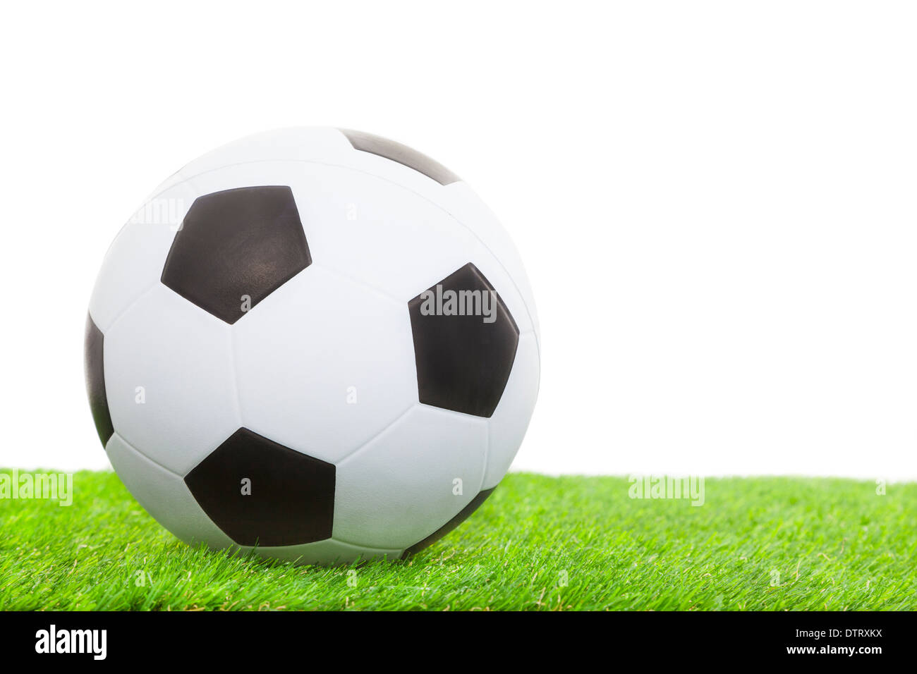Fußball auf dem grünen Rasen isoliert auf weißem Hintergrund Stockfoto