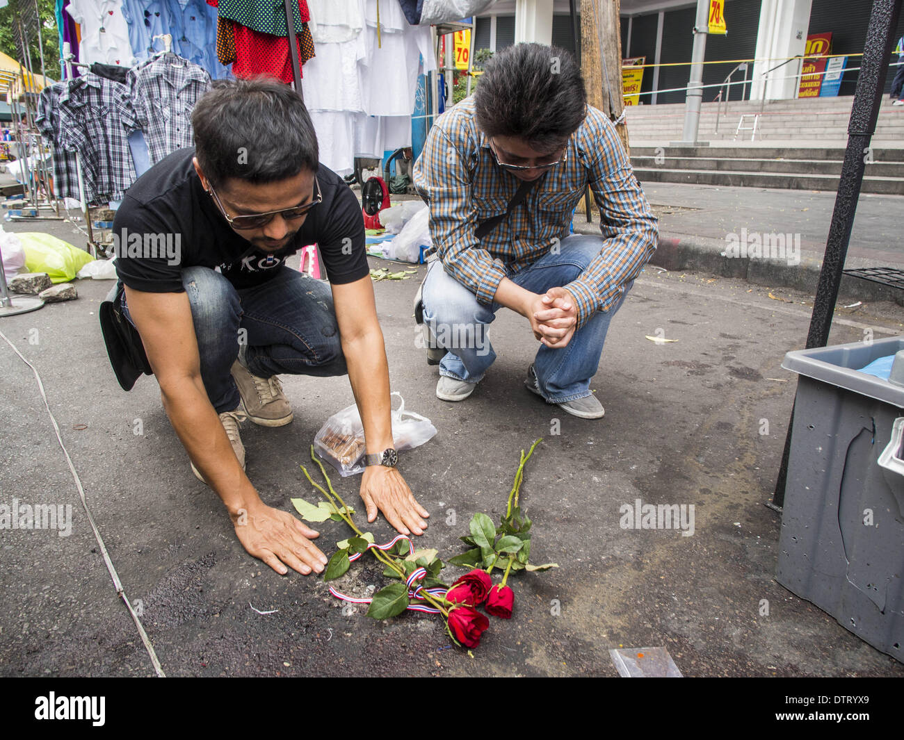 Bangkok, Thailand. 24. Februar 2014. Trauernde lassen Sie Blumen und beten an der Stelle, wo drei Menschen in einem Granatenanschlag auf Anti-Regierungs-Demonstranten im Stadtteil Ratchaprasong in Bangkok getötet wurden. Mindestens vier Personen, drei Kinder, starben in politischer Gewalt über das Wochenende in Thailand. Eine in der Provinz Trat, in der Nähe der kambodschanischen Grenze und drei in Bangkok an der Ratchaprasong-Protest-Website. Am Standort Ratchaprasong wurde eine Granate in eine Menschenmenge, die Tötung eines Kindes und eines Erwachsenen gefeuert. Bildnachweis: ZUMA Press, Inc./Alamy Live-Nachrichten Stockfoto