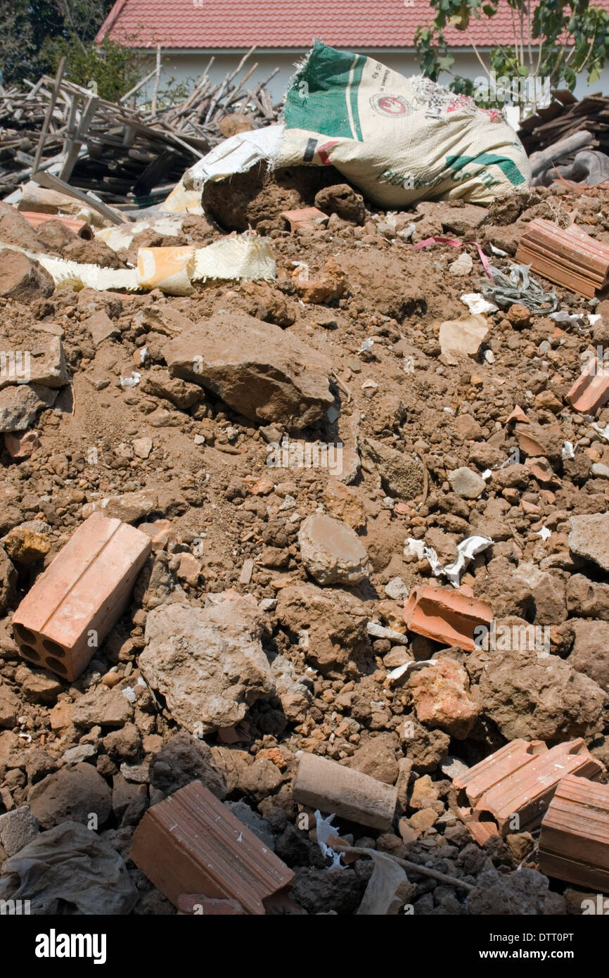 Ein Haufen von Schmutz übersät mit Steinen ruht vor einem Stapel Holz auf einer neuen Baustelle in Kampong Cham, Kambodscha. Stockfoto
