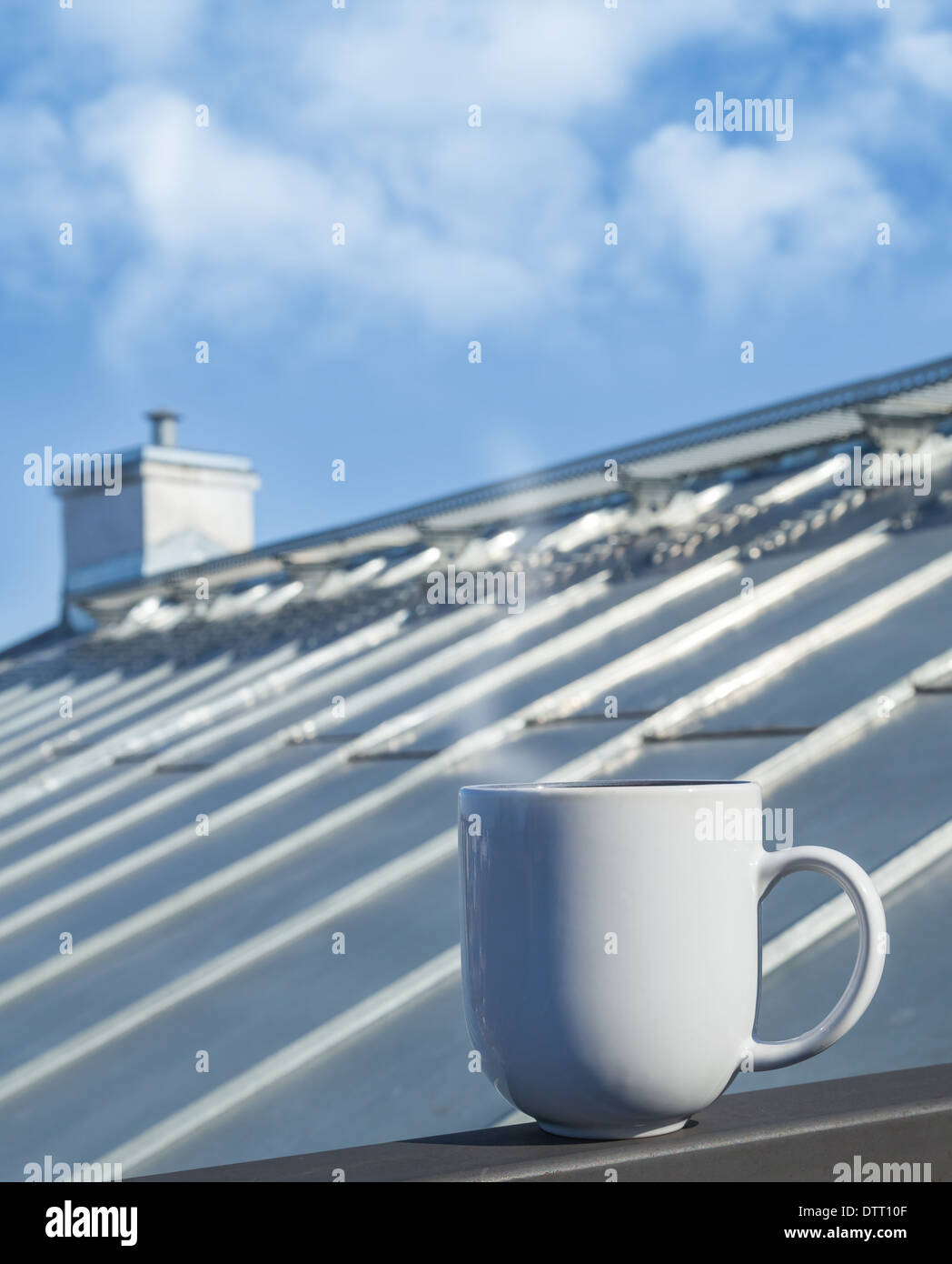 Weiße Tasse steht auf Balkongeländer mit Dach auf einem Hintergrund Stockfoto