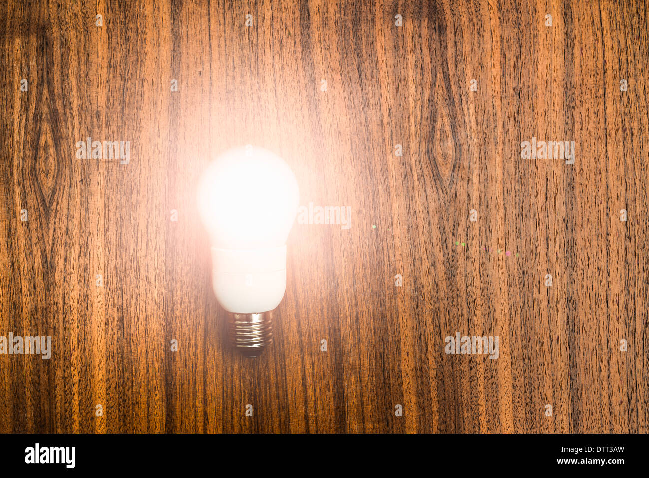 Beleuchtete Eco freundliche Glühbirne auf hölzernen Hintergrund. Konzeptbild von Ideen, Erfindungen und Erfolg mit Textfreiraum. Stockfoto