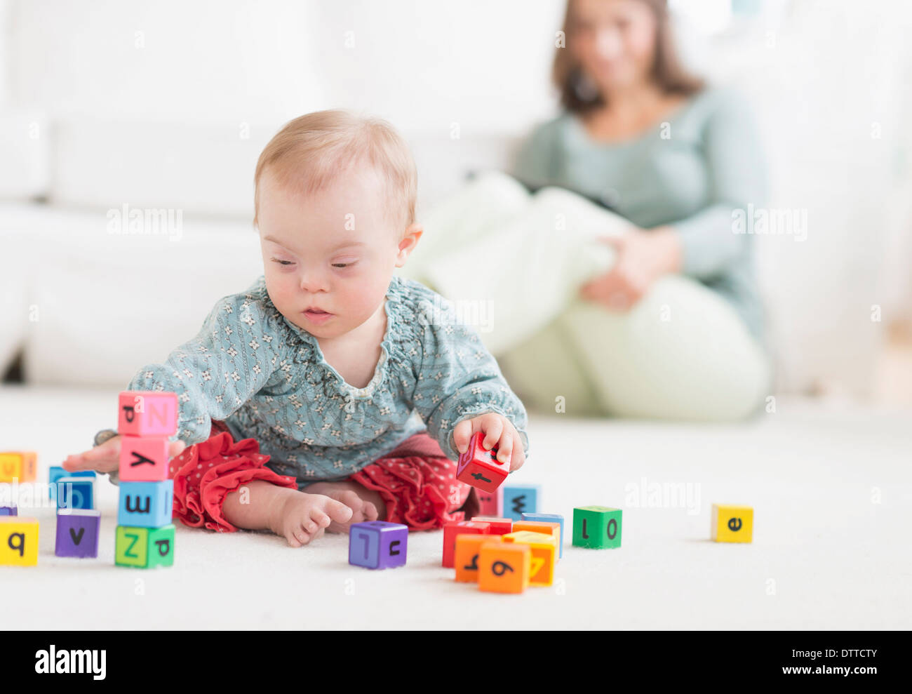 Kaukasische Mädchen mit Down-Syndrom mit Blöcke spielen Stockfoto