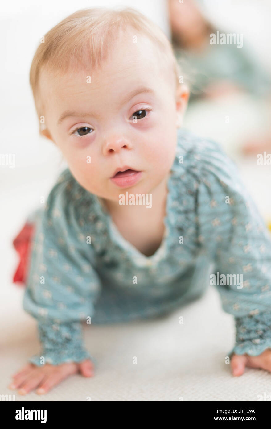 Kaukasische Mädchen mit Down-Syndrom, kriechen Stockfoto