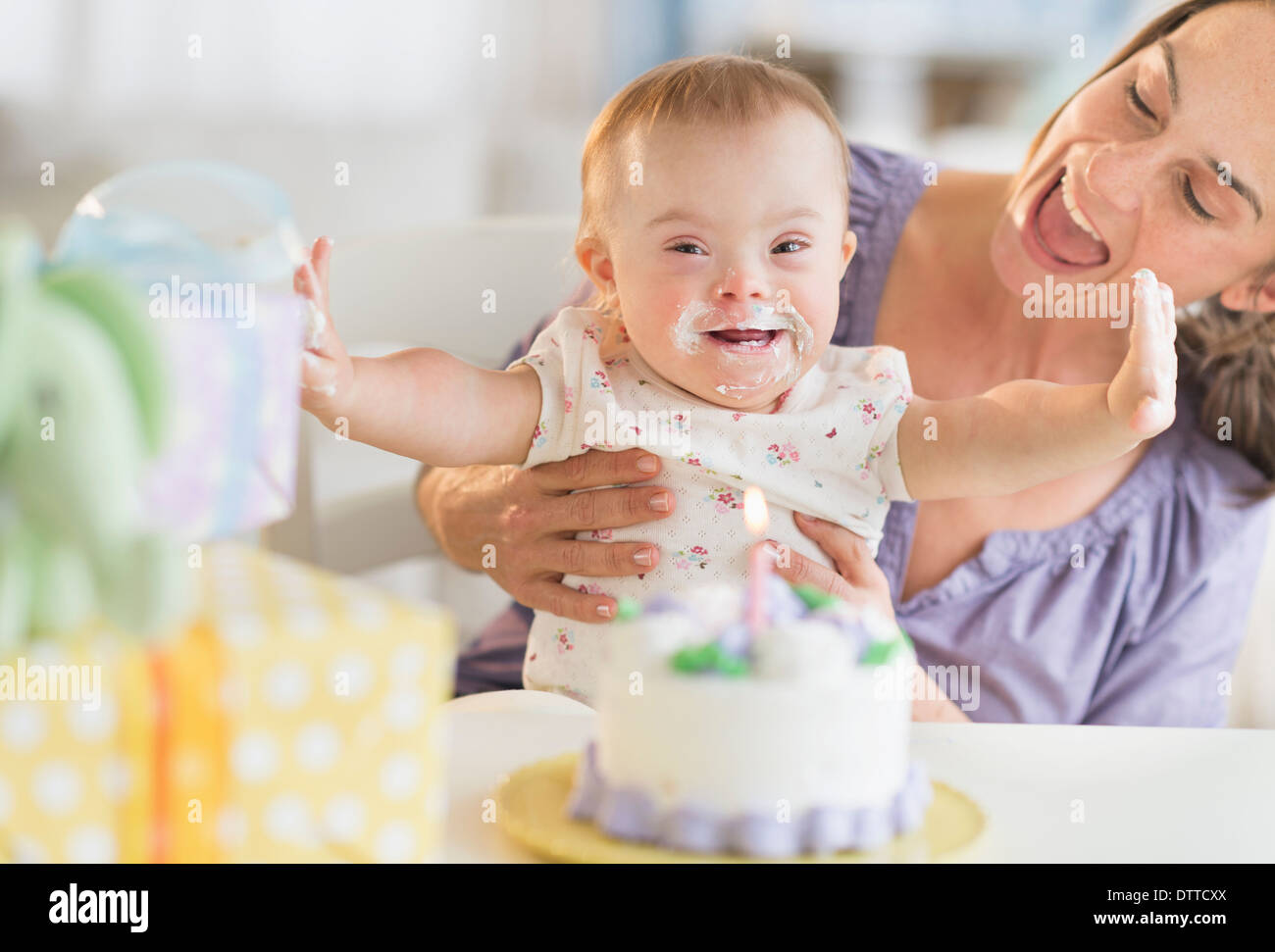 Kaukasische Mutter und Babymädchen mit Down-Syndrom feiert Geburtstag Stockfoto