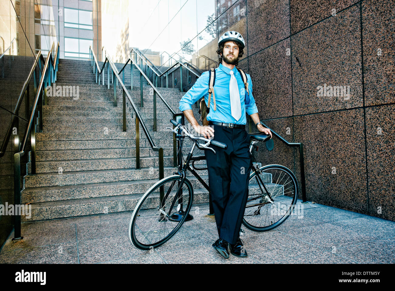 Kaukasische Geschäftsmann mit Fahrrad auf städtischen Treppe Stockfoto