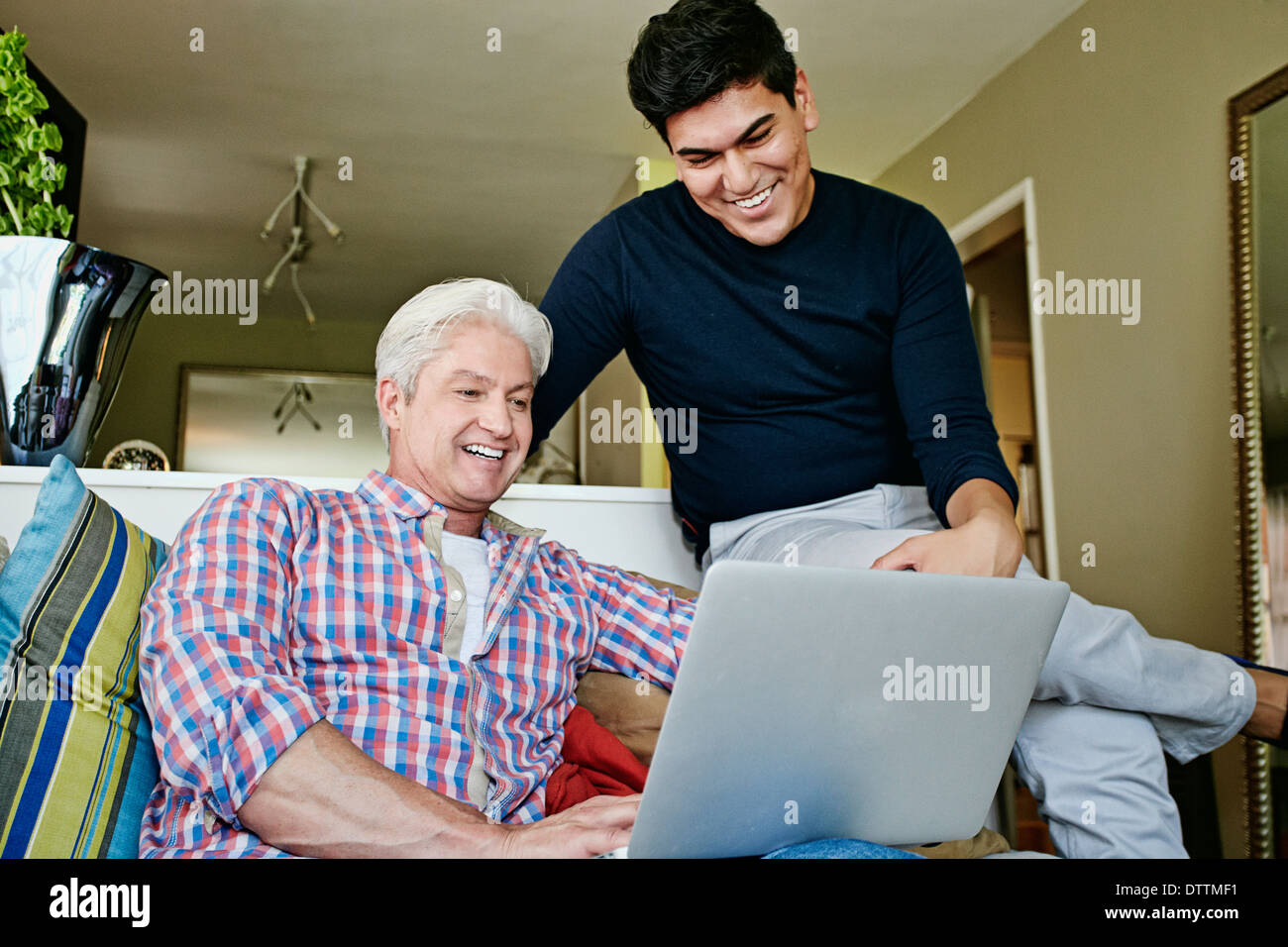Homosexuelles Paar mit Laptop im Wohnzimmer Stockfoto