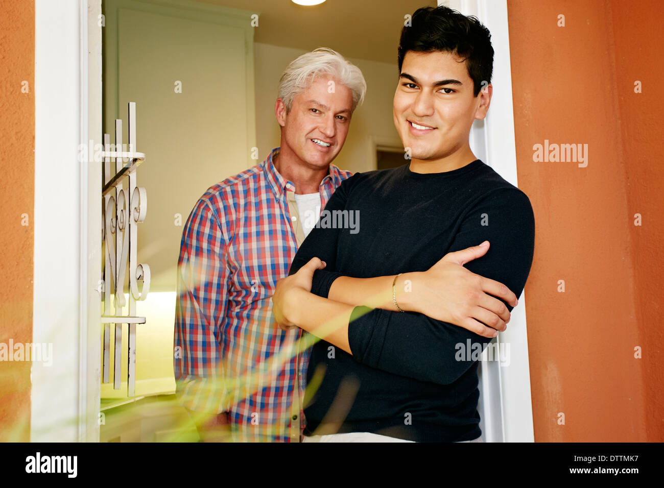 Homosexuelles Paar lächelnd in der Tür Stockfoto