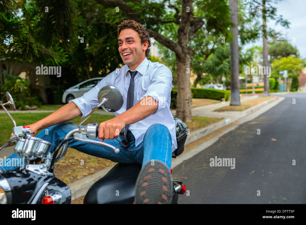 Hispano-Amerikaner Geschäftsmann fahren moped Nachbarschaft unterwegs Stockfoto