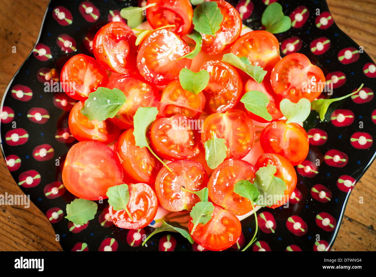 Salat von Kirschtomaten auf interessante schwarze Platte Stockfoto