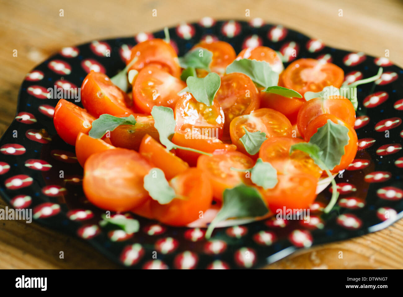 Salat von Kirschtomaten auf interessante schwarze Platte Stockfoto