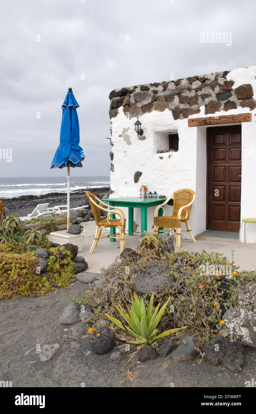 Vulkanischen Stein Ferienwohnungen auf einem steinigen Strand auf Lanzarote Kanarische Inseln Stockfoto