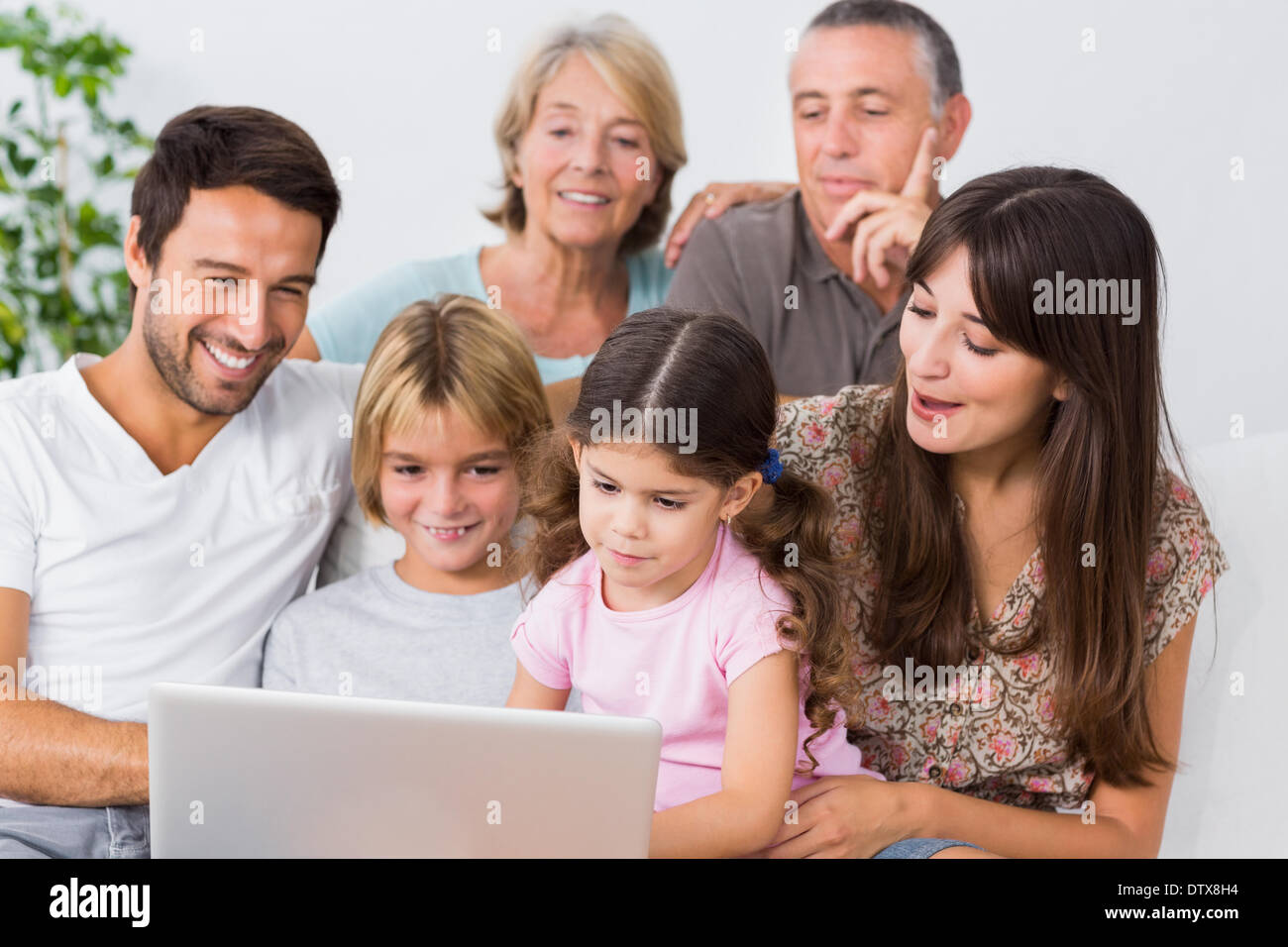 Lächelnde Familie gerade etwas auf laptop Stockfoto