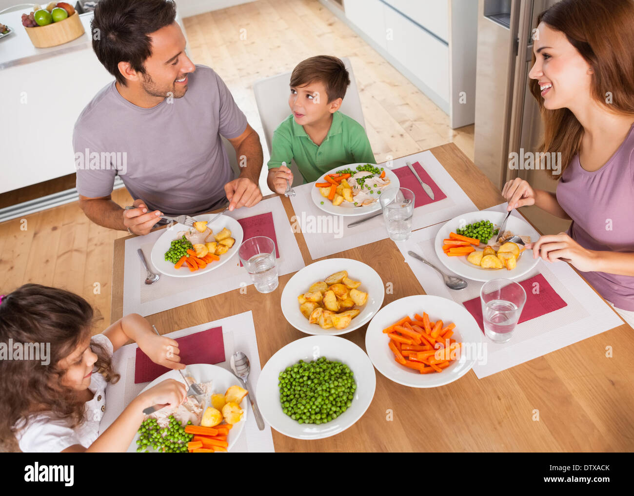 Familie lächelnd um eine gesunde Mahlzeit Stockfoto