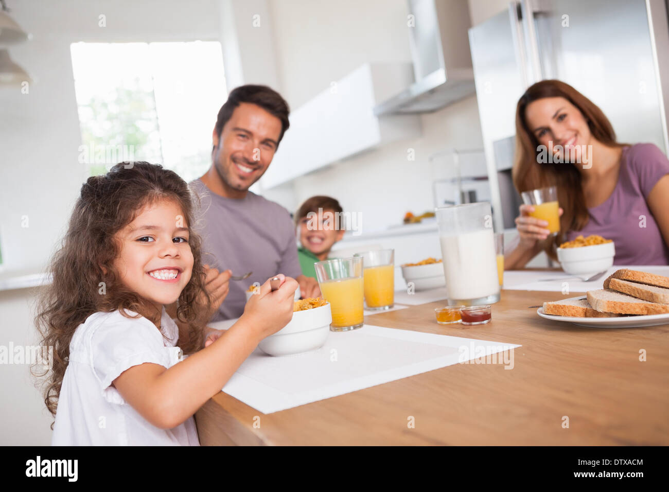 Familie lächelt in die Kamera beim Frühstück Stockfoto