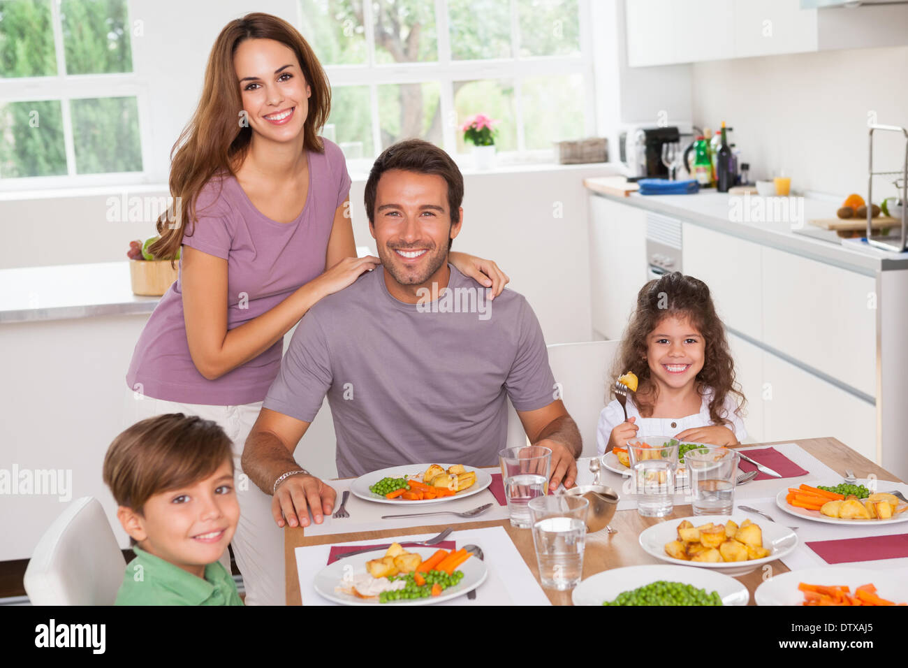Familie am Esstisch lächelnd Stockfoto