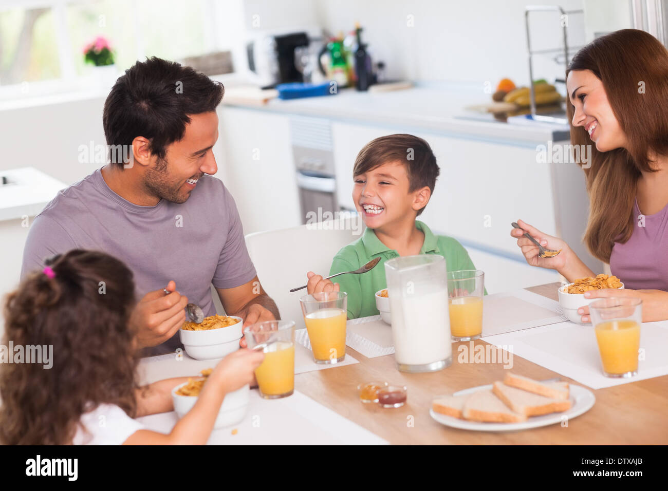 Familie lachen um Frühstück Stockfoto