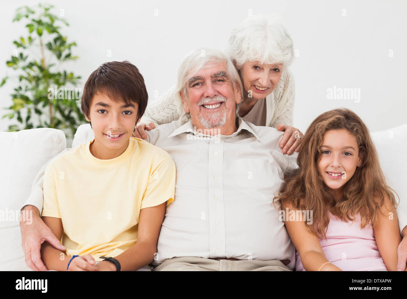 Großeltern mit Enkeln auf dem sofa Stockfoto