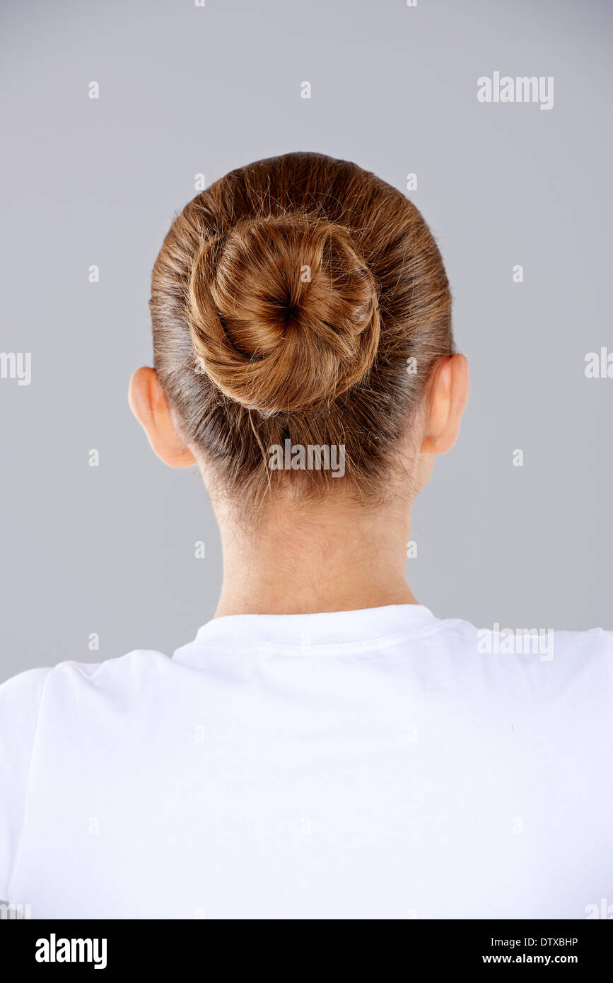 Brünette Haare in einem ordentlichen Brötchen Stockfoto