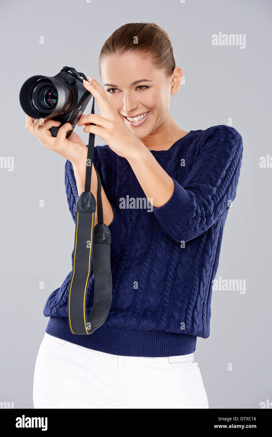 Glückliche Frau hält eine professionelle Kamera Stockfoto
