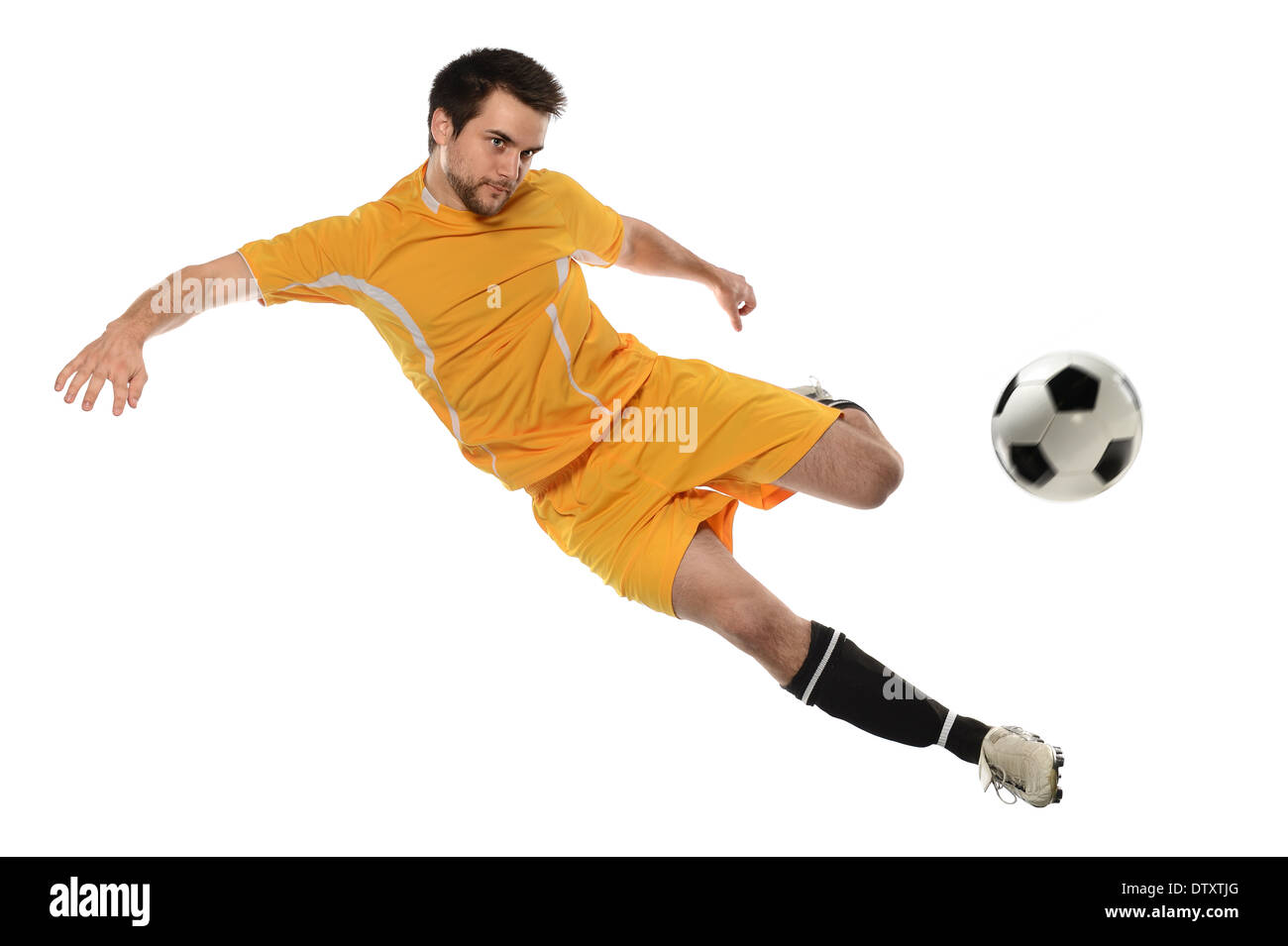 Junge Fußballer treten Ball isoliert auf weißem Hintergrund Stockfoto