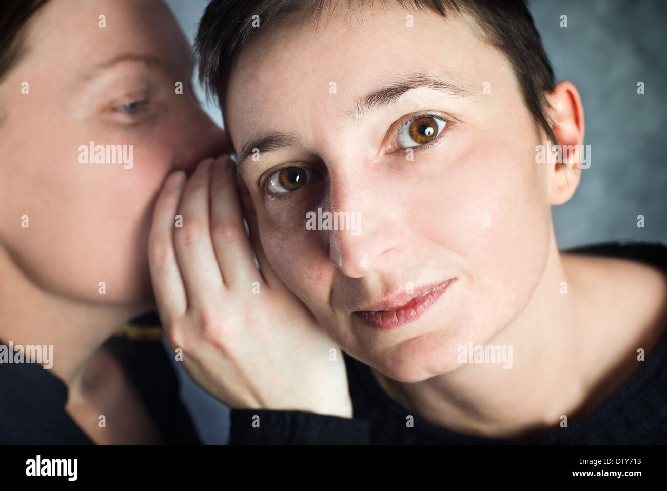 Zwei Frauen tratschen, Geheimnisse oder Hörensagen Geschichten zueinander zu sagen. Stockfoto