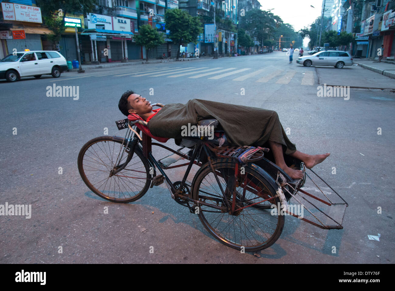 Rikscha-Fahrer schlafen auf seine Rikscha in den Straßen von Yangon. Myanmar (Burma). Stockfoto