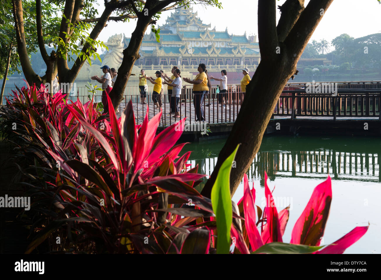 Morgen Übungen im Kandogyi Park mit Karaweik Hall in Bckgrd. Yangon. Myanmar (Burma). Stockfoto