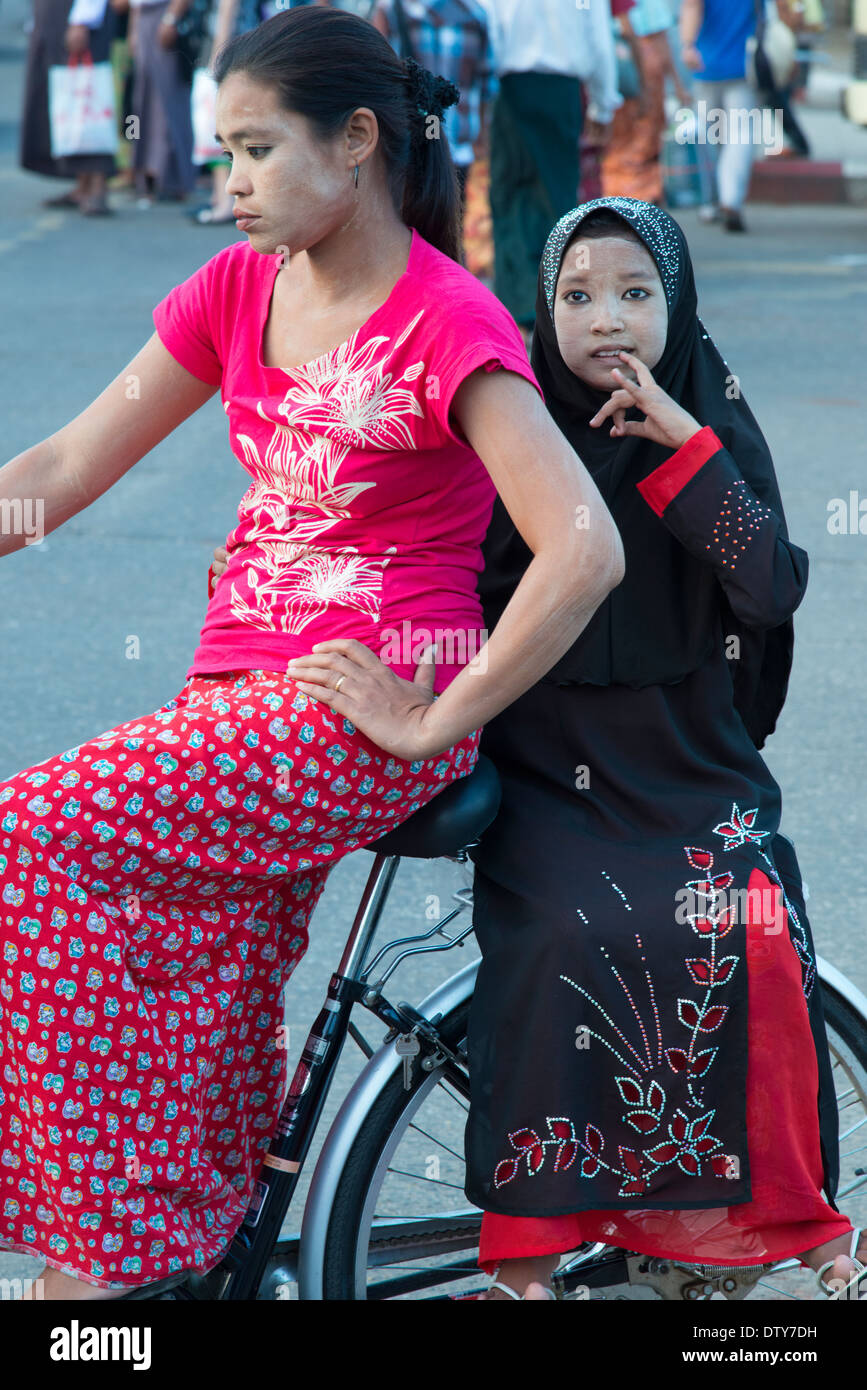 Junge Frau mit Mädchen trägt einen Schleier auf dem Fahrrad. Yangon. Myanmar (Burma). Stockfoto