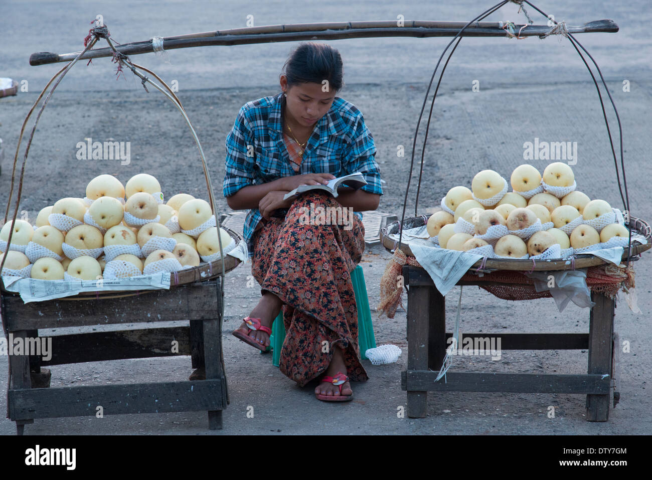 Junge Frau verkaufen Äpfel an einem tragbaren Stand in den Straßen von Yangon. Myanmar (Burma). Stockfoto