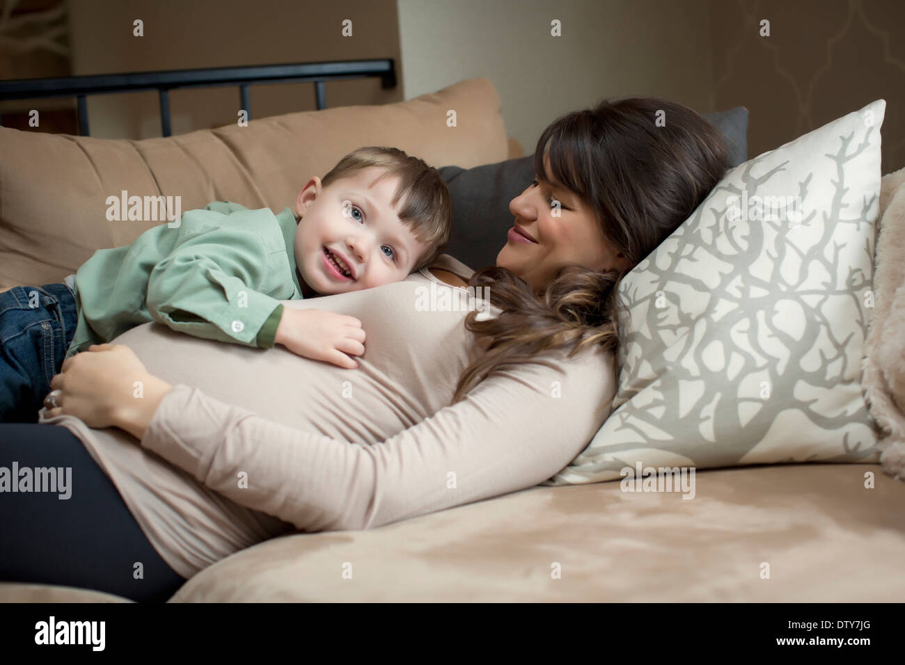 Schwangere Frau kaukasischen Verlegung mit Sohn Stockfoto