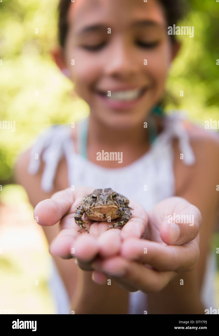 Gemischte Rassen Mädchen Holding Frosch im freien Stockfoto