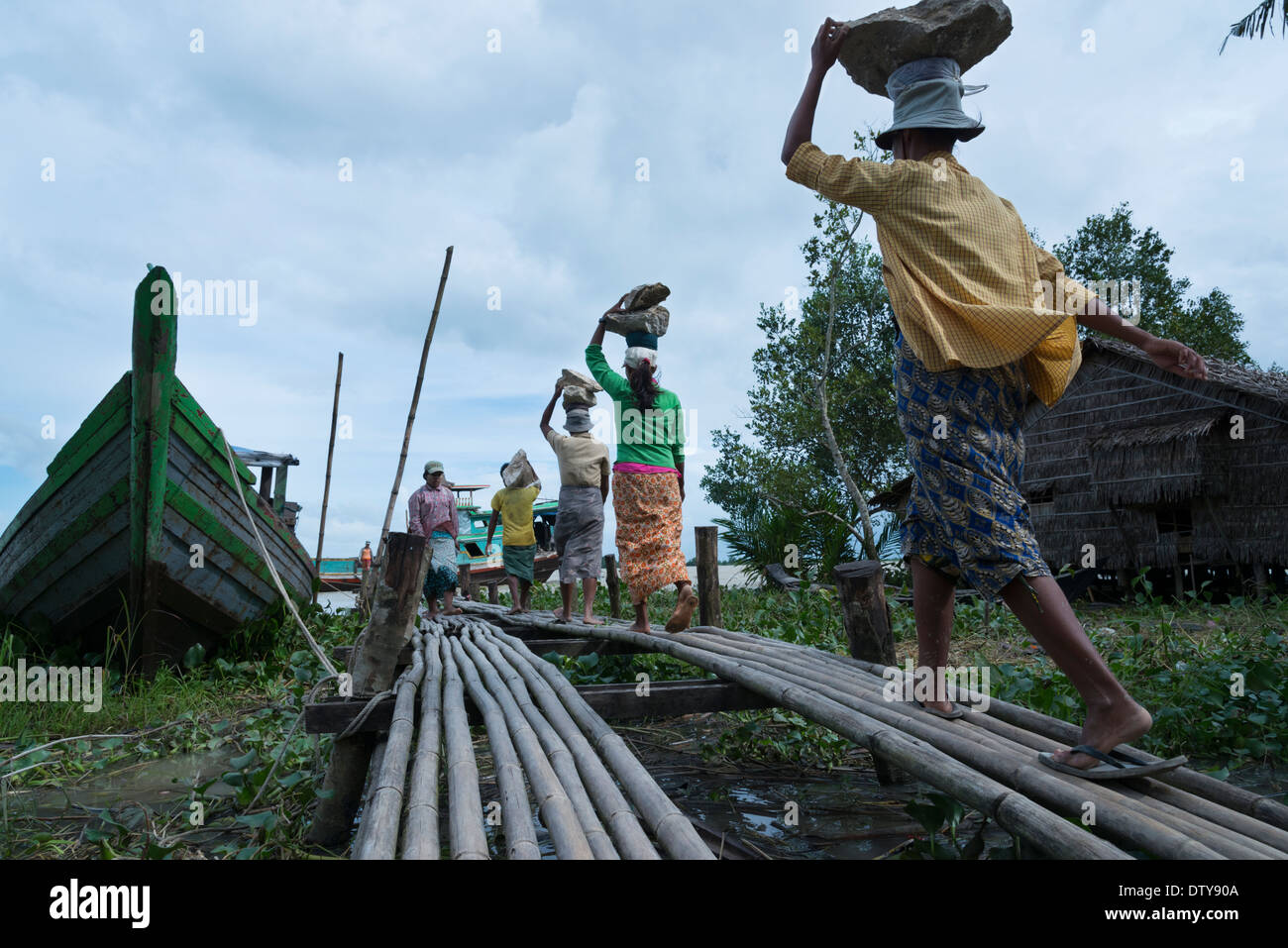 Weibliche Träger mit Steinen auf einem Fluss-Steg. Irrawaddyi Abteilung. Myanmar (Burma). Stockfoto