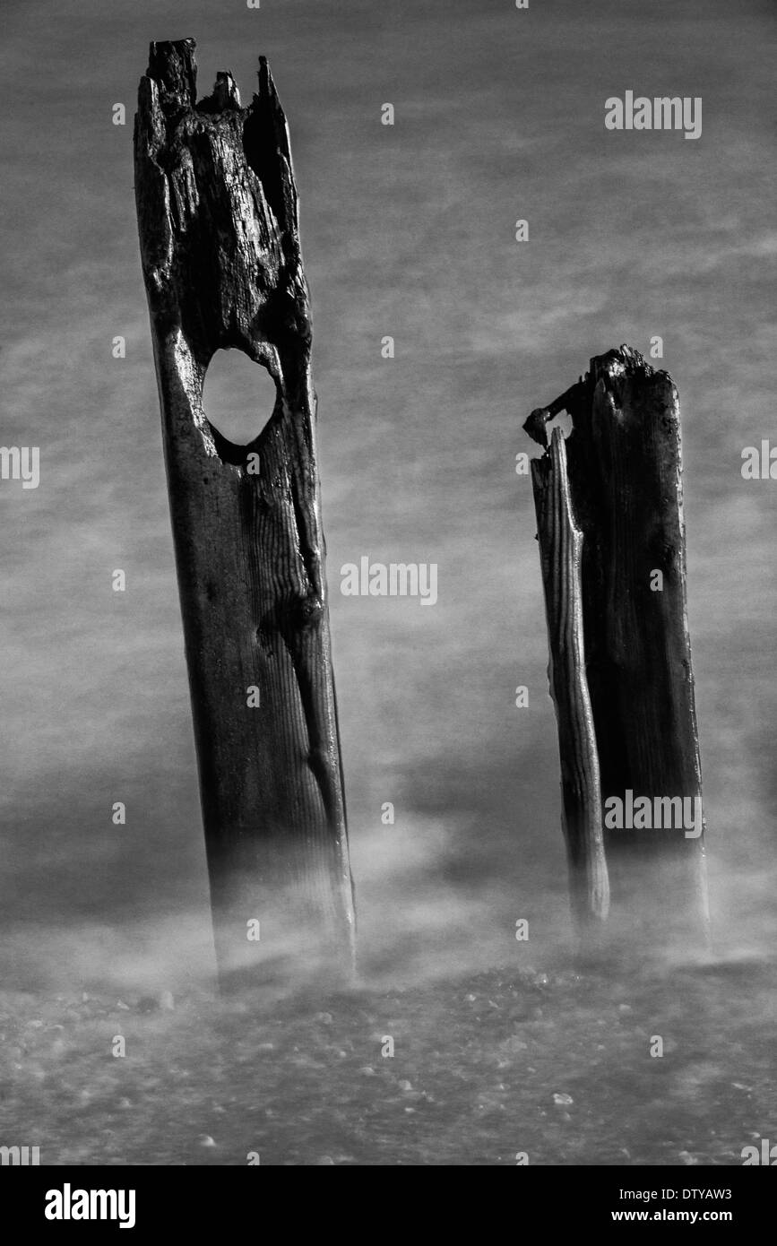 Das Meer wäscht auf den Resten eines längst vergangenen Steg entlang des Strandes von Winchelsea in East Sussex. UK Stockfoto
