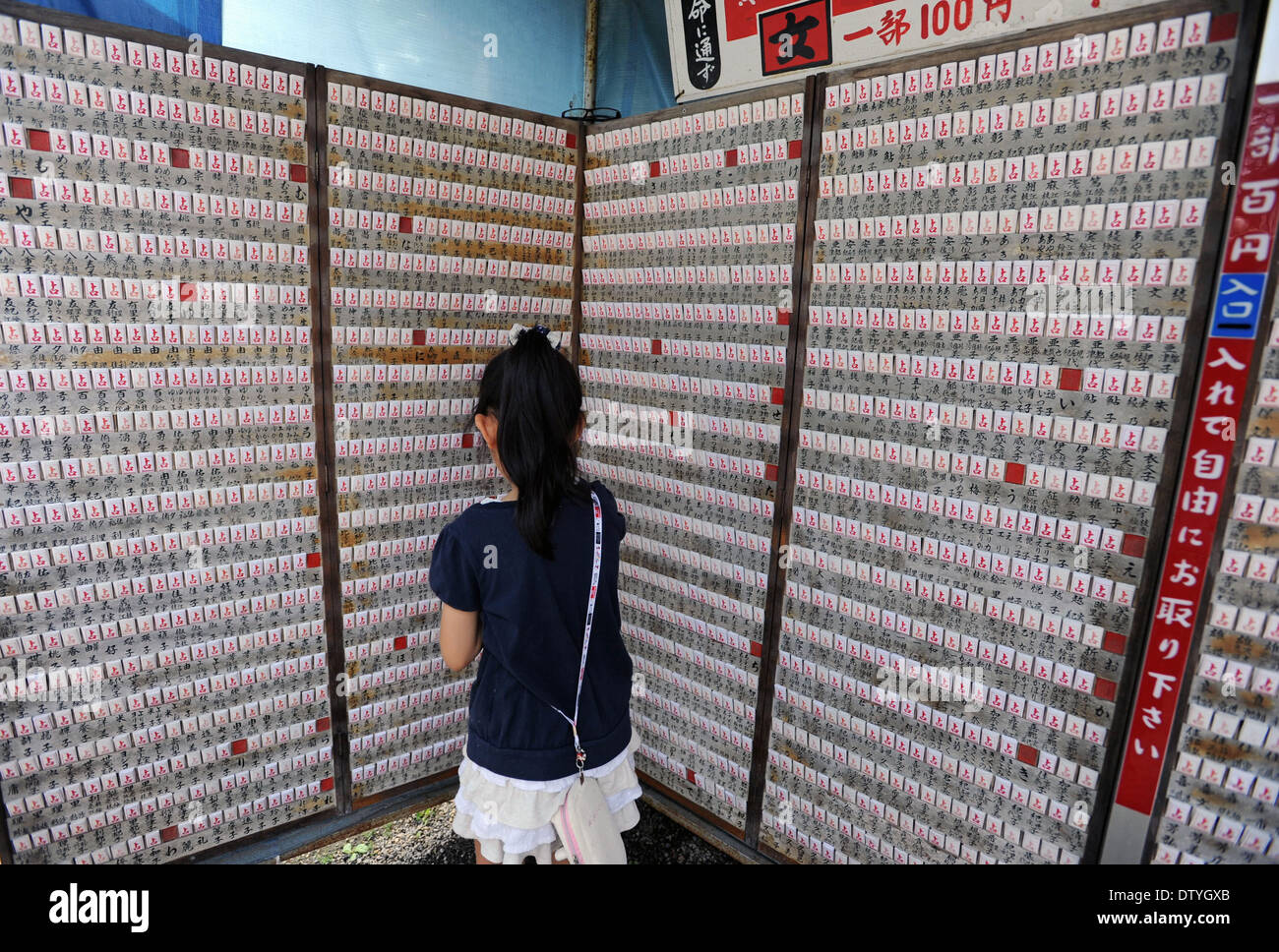 Eine Mädchen nimmt Omikuji, Japanpapier Orakel, von Ueugi Jinjya in Yonezawa, Yamagata. Stockfoto