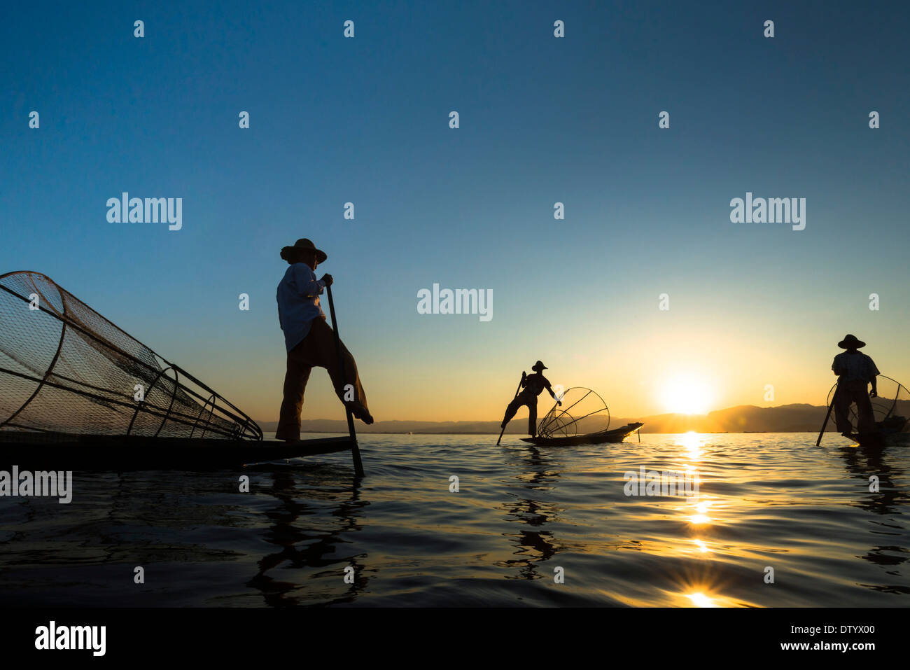 Fischer im Abendlicht, Bein Ruderer mit traditionellen Körben auf ihren Kanus, Sonnenuntergang, Inle-See, Shan State in Myanmar Stockfoto