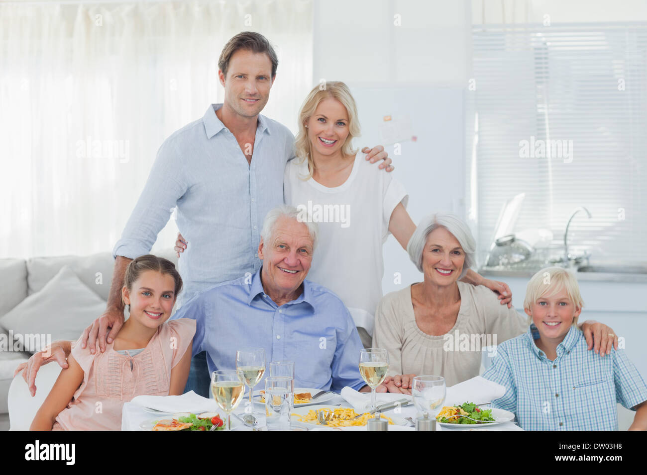 Großfamilie lächelnd am Esstisch Stockfoto