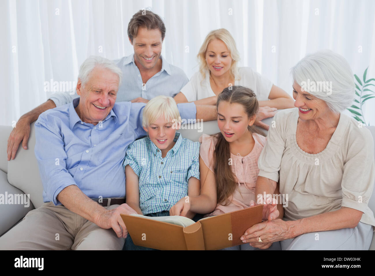 Großfamilie mit Blick auf ein Foto album Stockfoto