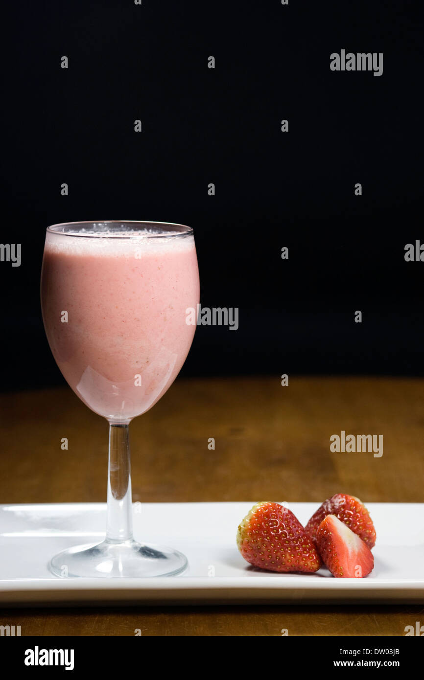 Erdbeer Smoothie und Früchte auf einem weißen Teller. Stockfoto