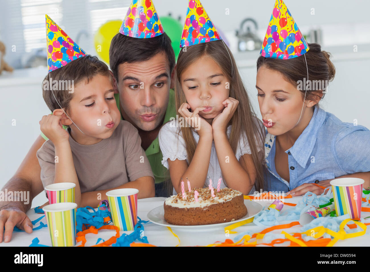 Familie bläst Kerzen zusammen Stockfoto