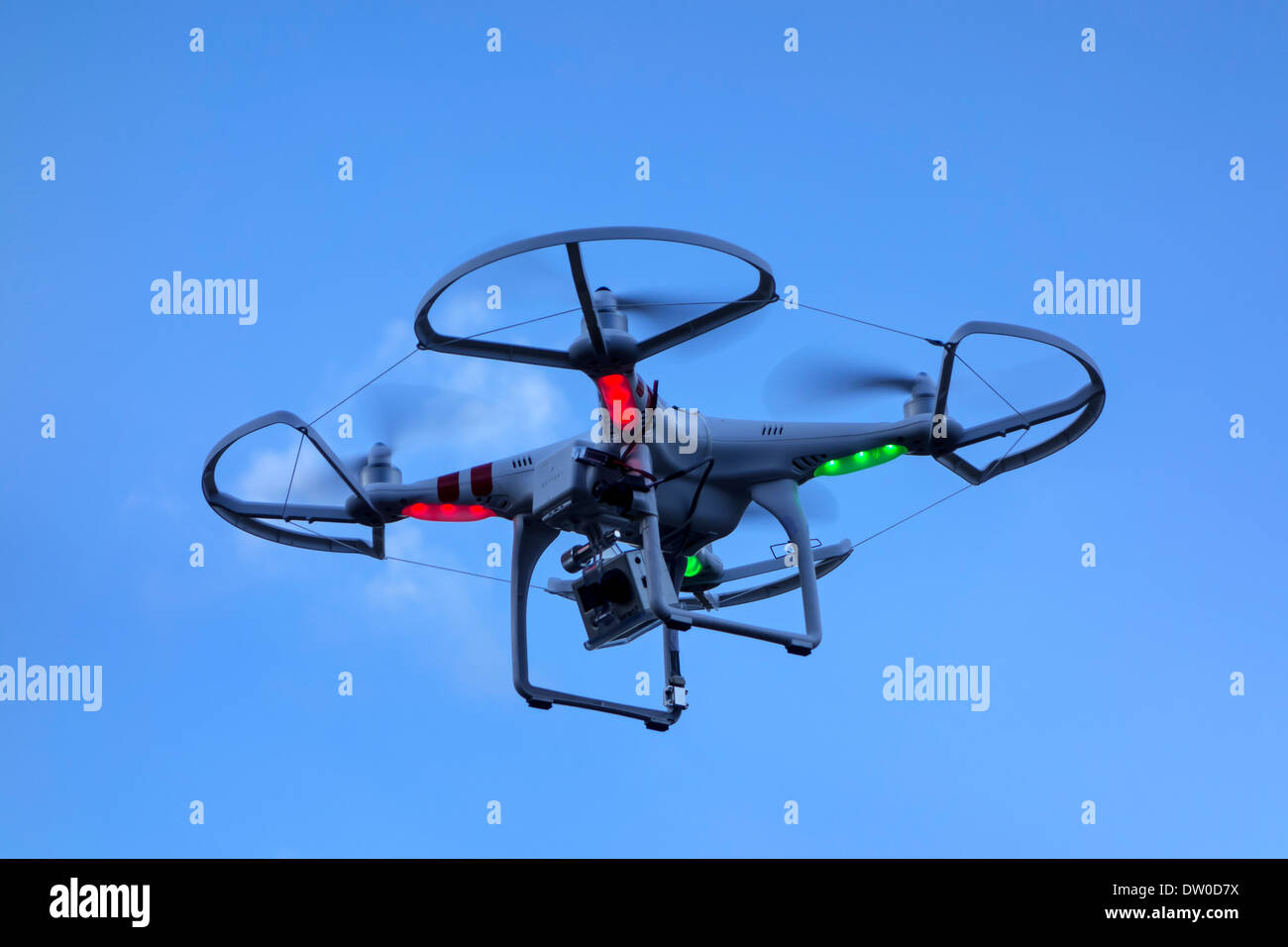 Miniatur-Drohne / unmanned aerial vehicles / UAV ausgestattet mit Kamera im Flug gegen blauen Himmel mit Wolken Stockfoto