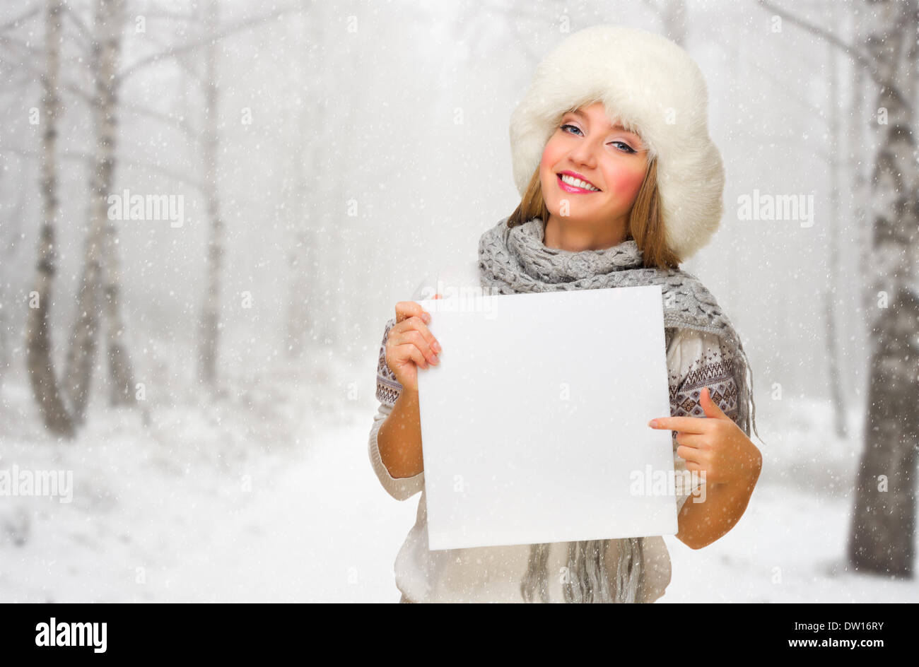 Junges Mädchen mit leeren Karte im verschneiten Wald Stockfoto