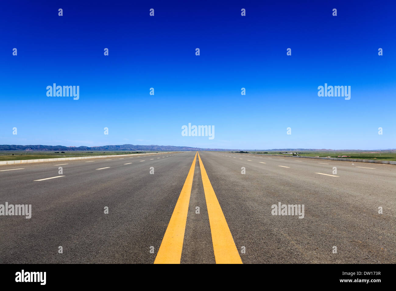 Autobahn in der Steppe vor blauem Himmel Stockfoto