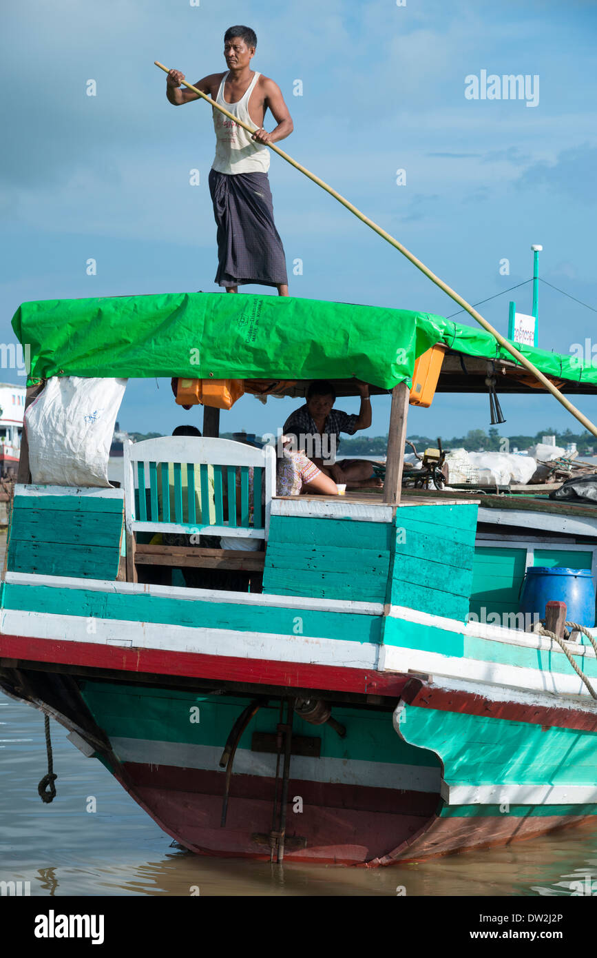 Bootseigner sein Boot zu manövrieren. Hafen von Yangon. Myanmar (Burma). Stockfoto