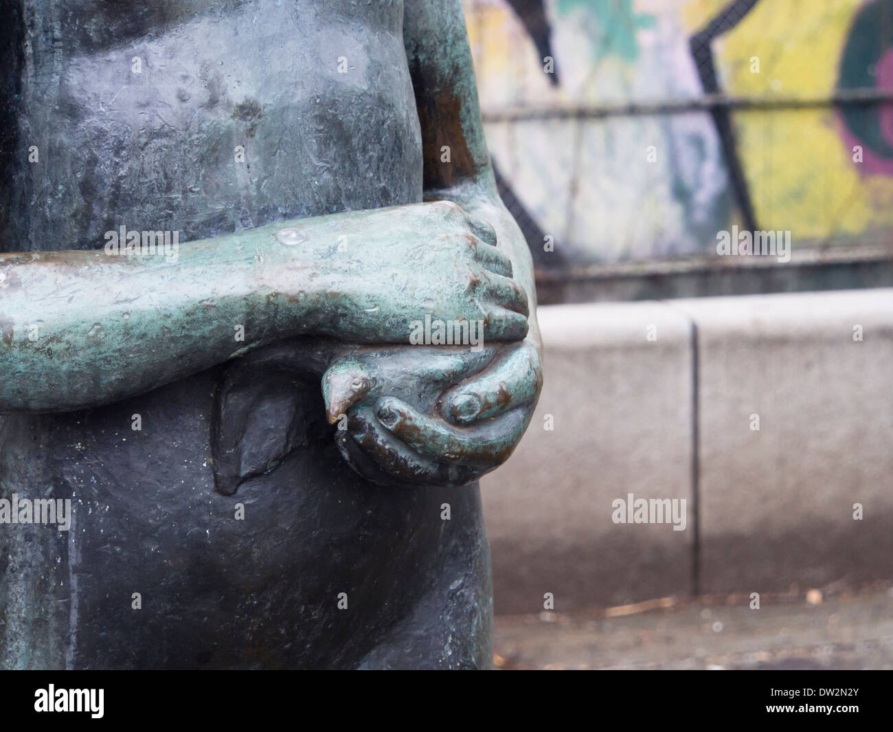 Nahaufnahme eines Teils der Statue in Bronze, Mädchen Händen mit Taube, verschwommen Graffiti an der Wand, Oslo Norwegen Stockfoto