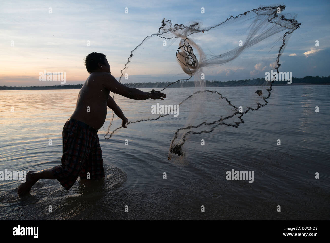 Mann wirft ein Fischernetz in der Abenddämmerung. Mekong-Fluss. Kambodscha. Stockfoto