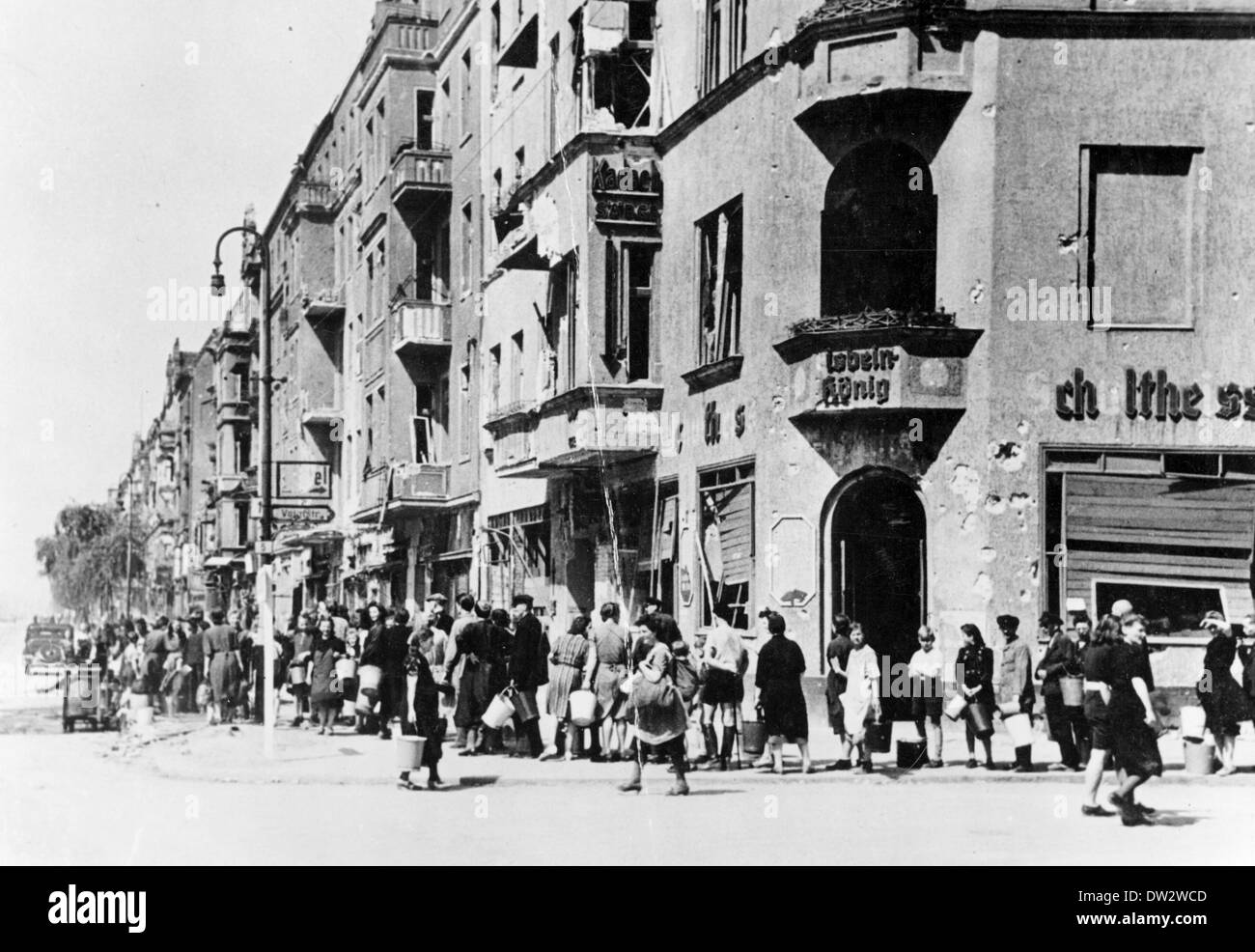 Frauen, Männer und Kinder stehen an einer funktionierenden Wasserpumpe in der Voigtstraße nahe der Frankfurter Allee in Berlin im April/Mai 1945 in Schlange. Fotoarchiv für Zeitgeschichtee - KEIN KABELDIENST Stockfoto